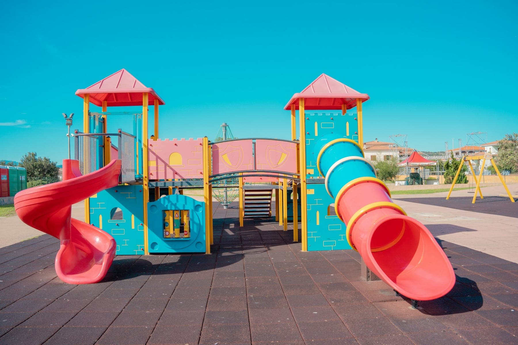 An outdoor play structure with a tube slide on a sunny day