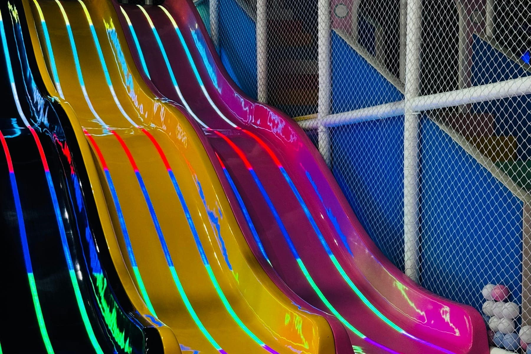 Three slides ending in a ball pit inside a play structure